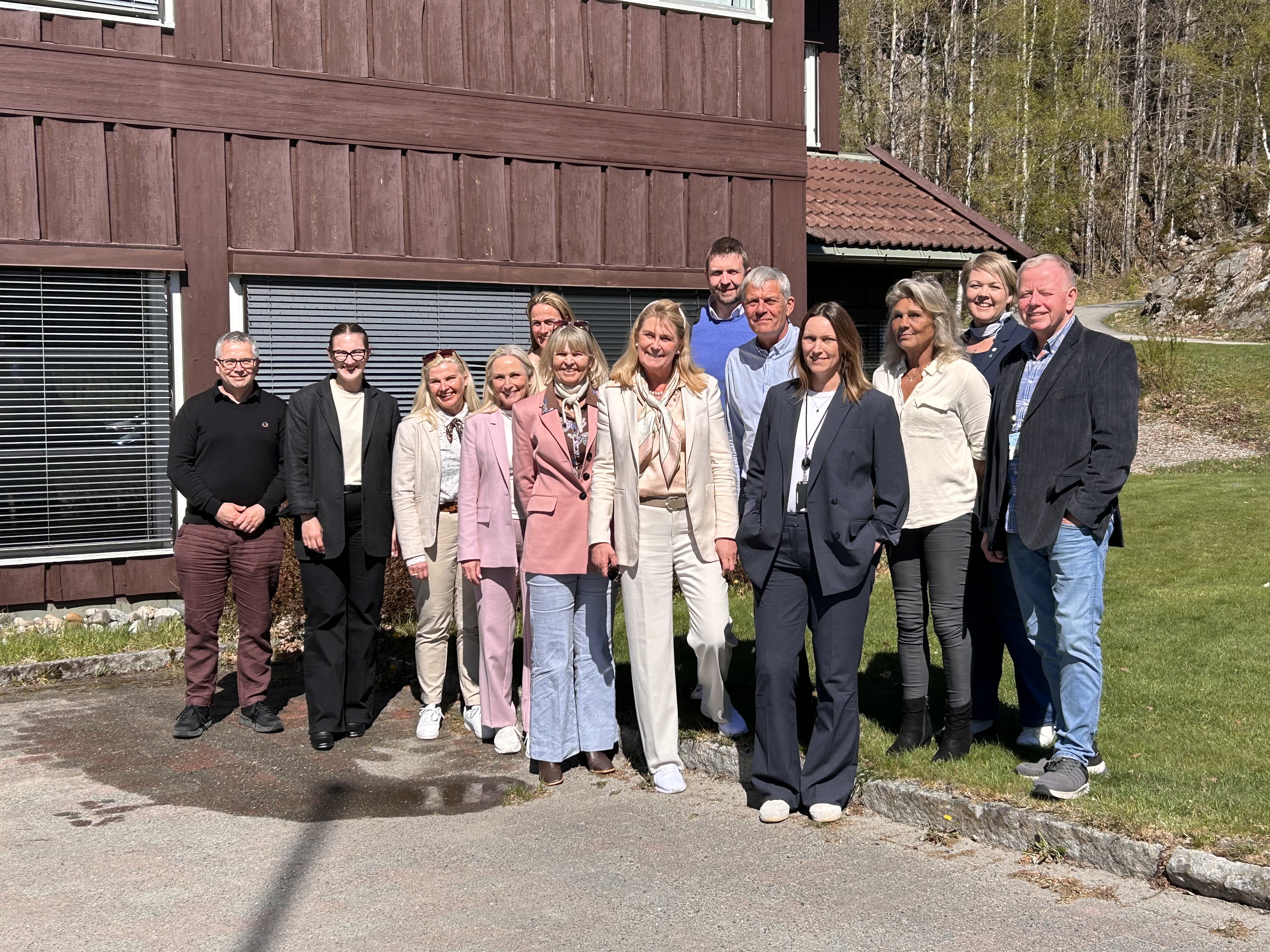 En gruppe smilende mennesker utendørs.