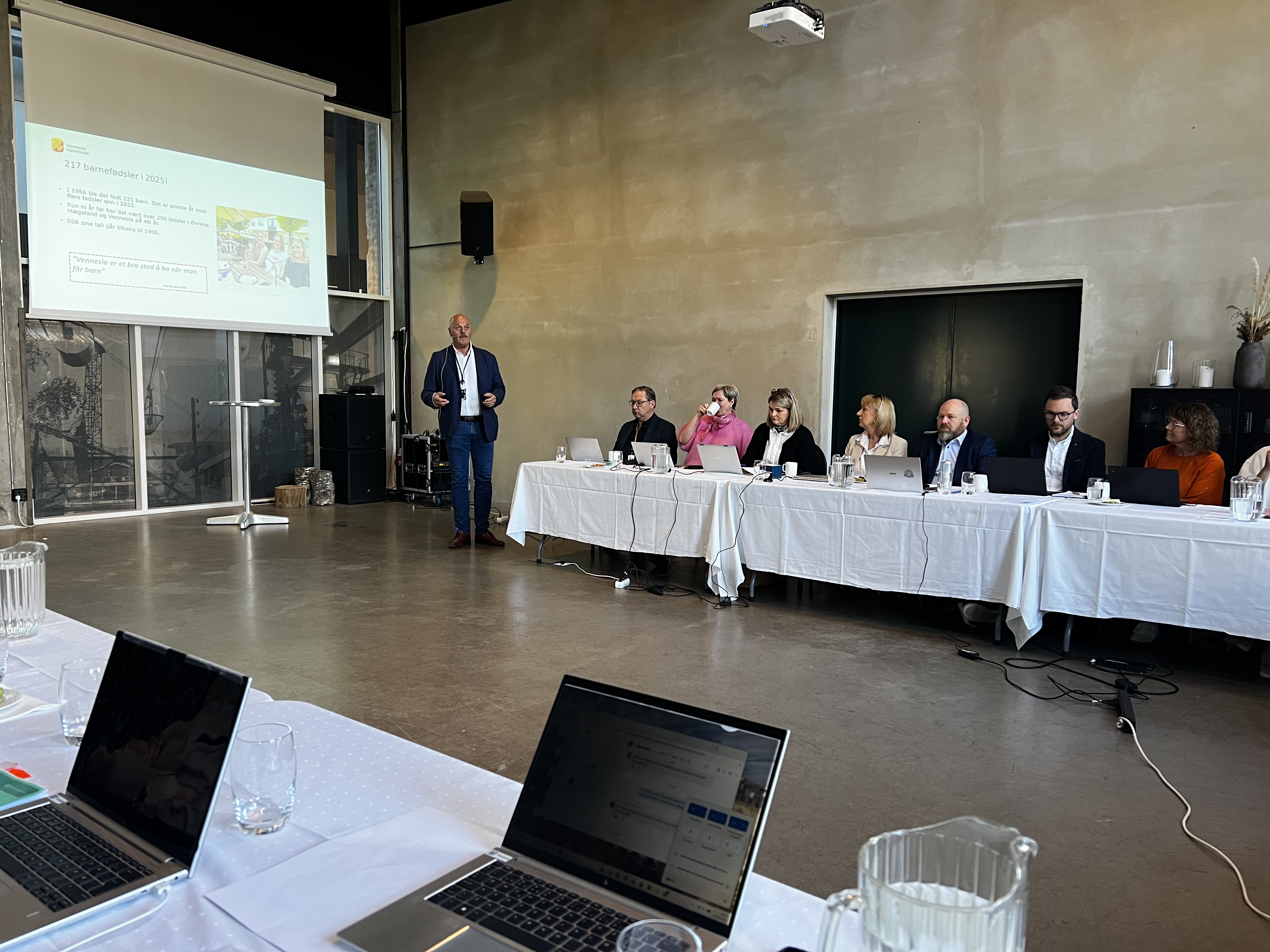 Mennesker i møterom. Presentasjon på skjerm, med fokus på gledelig nyhet om mange barnefødsler i 2025. 