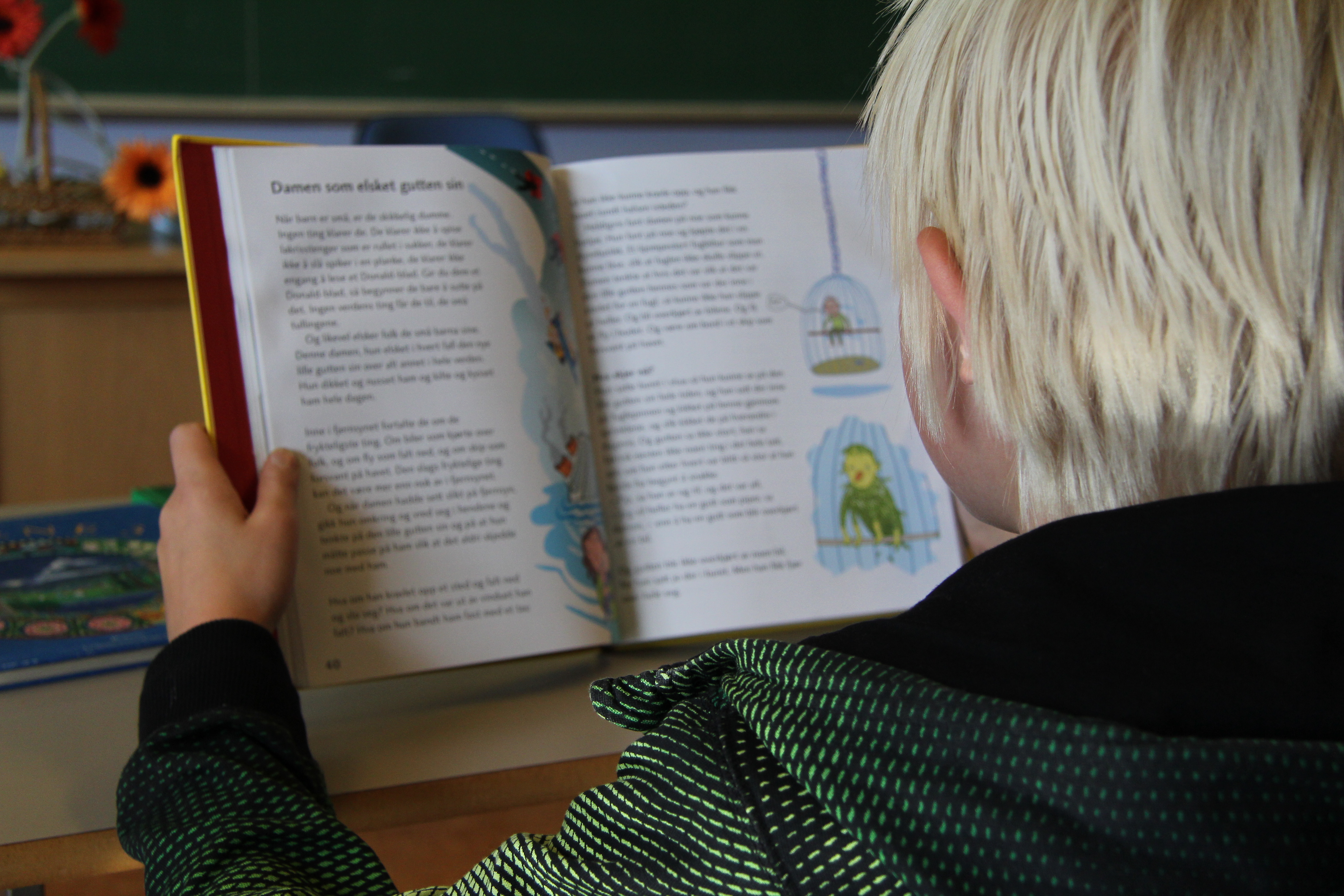 Ung gutt som leser i en bok