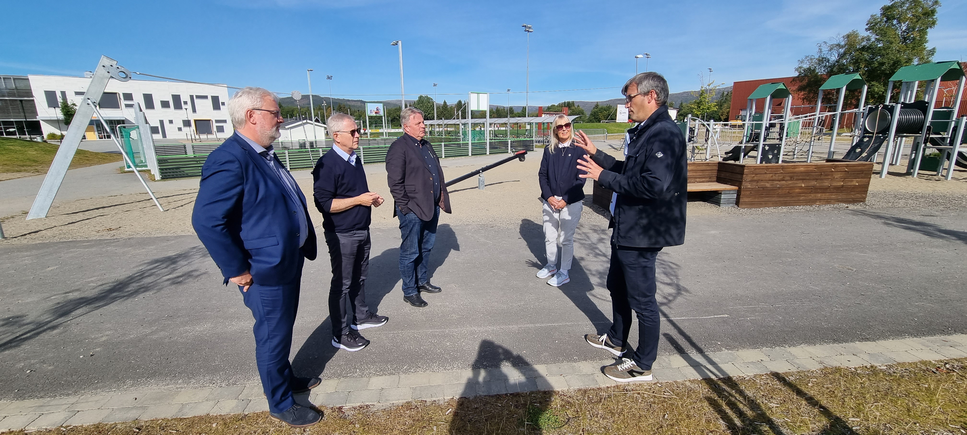 Varaordfører i Overhalla Johan Brøndbo Tetlien Sellæg (t.h) viser stolt fram uteområdet ved Overhalla barne og ungdomsskole til Statsforvalterens ledergruppe, her representert med Frank Jenssen, Jan Vaage, Øystein Johannessen og Mari Mogstad.