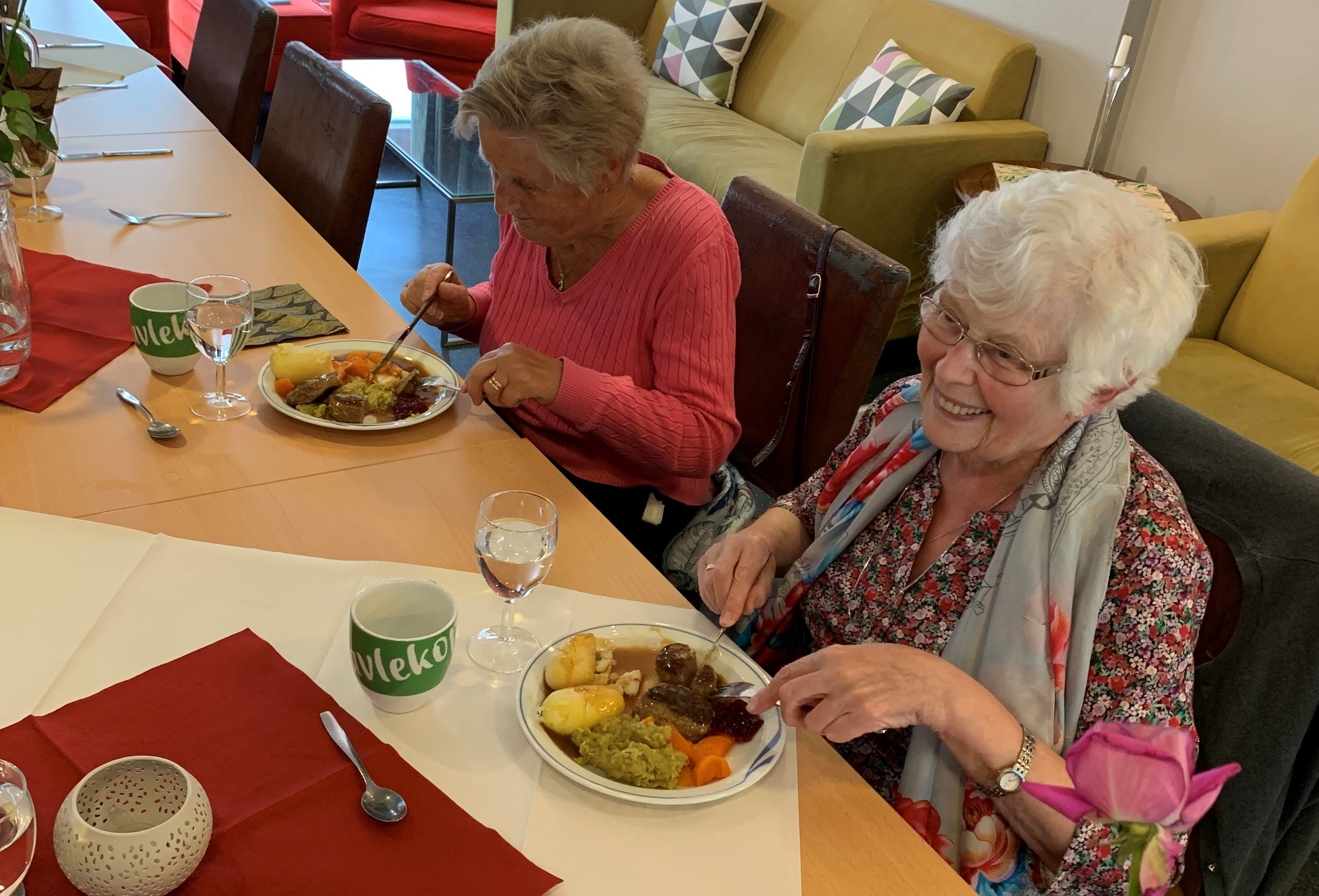Smilene sitter løst rundt bordet på Tusenhjemmet i Bodø. Her kan eldre få gratis middag en gang i uken denne høsten.