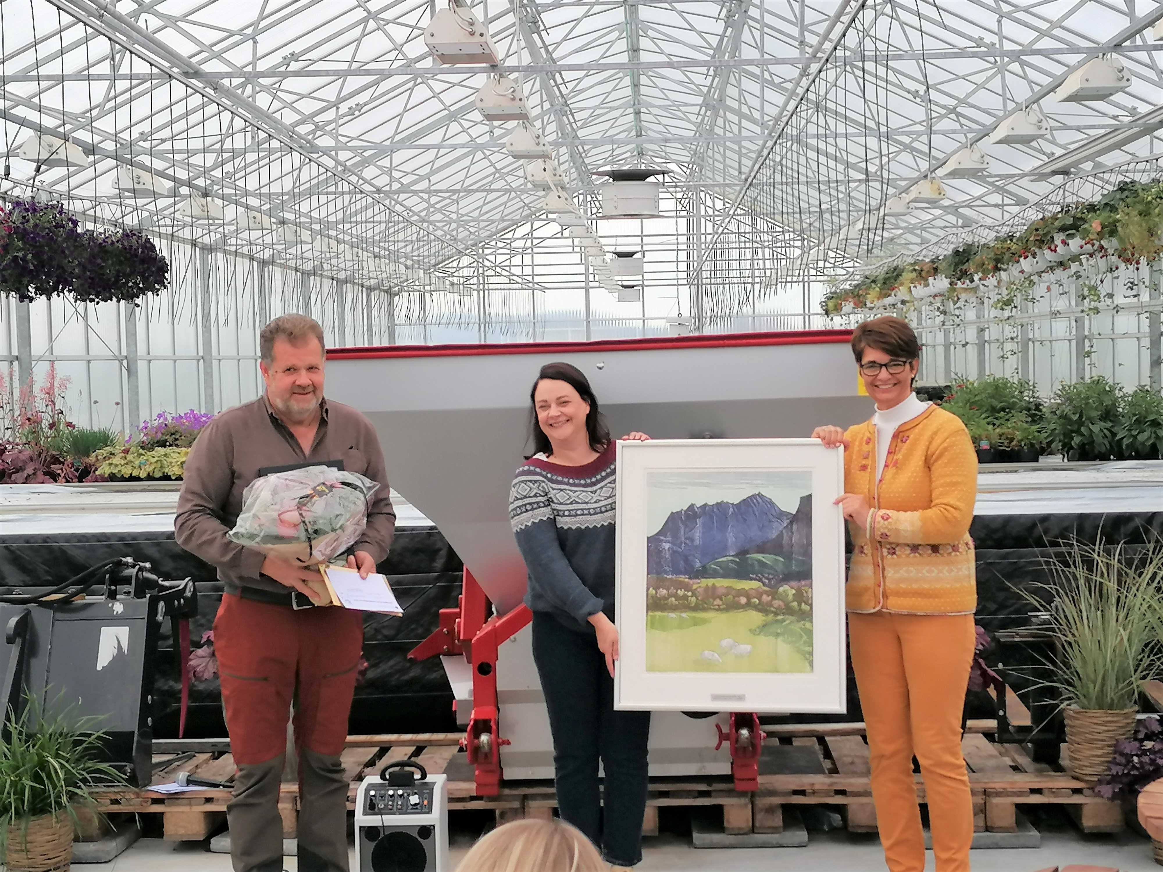 Vi ser Egil Kvalsund får blomar og kunst av fylkesordføraren og konstituert statsforvaltar. 