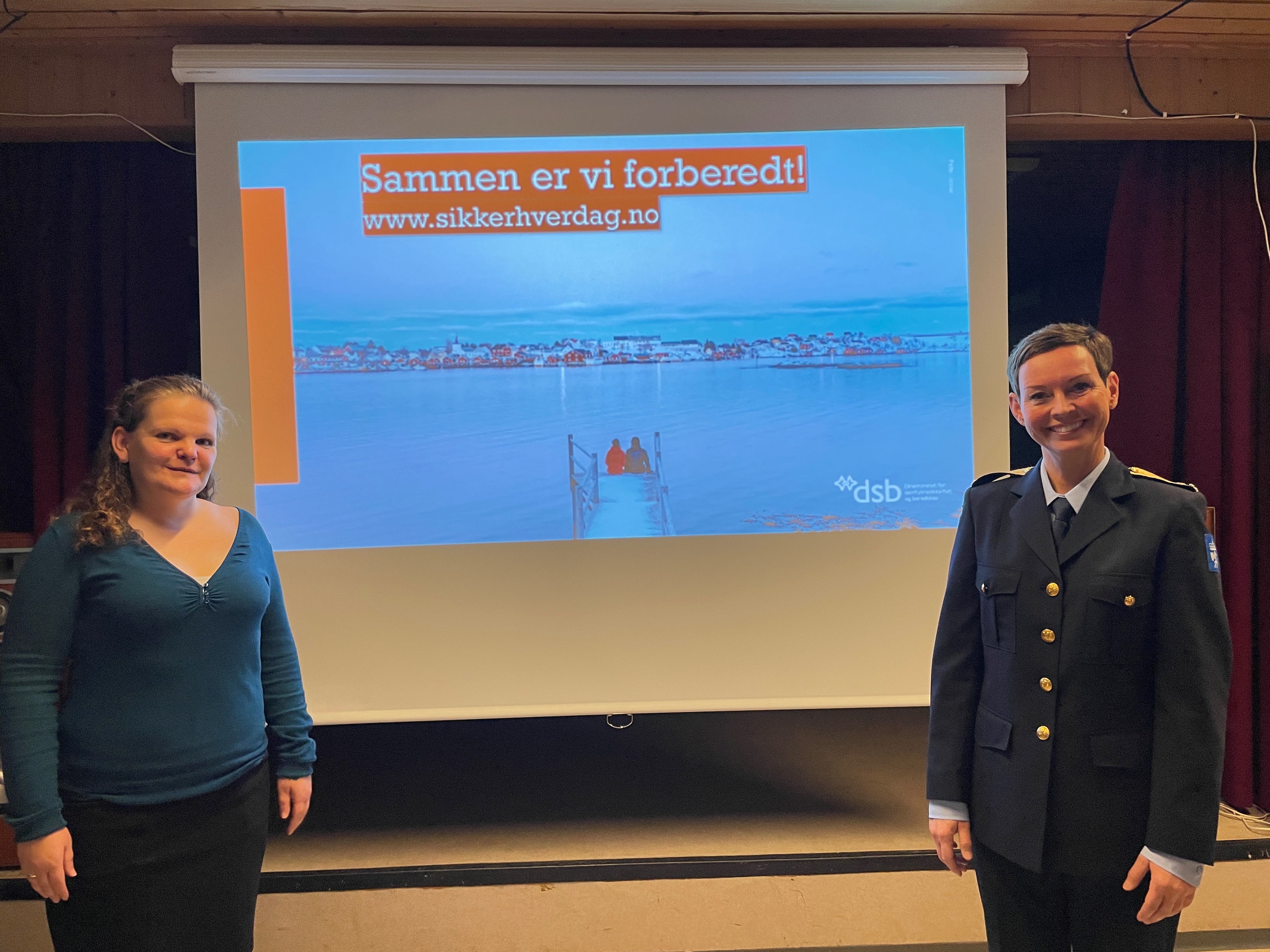 To damer fremfor et lerret som viser en presentasjon.