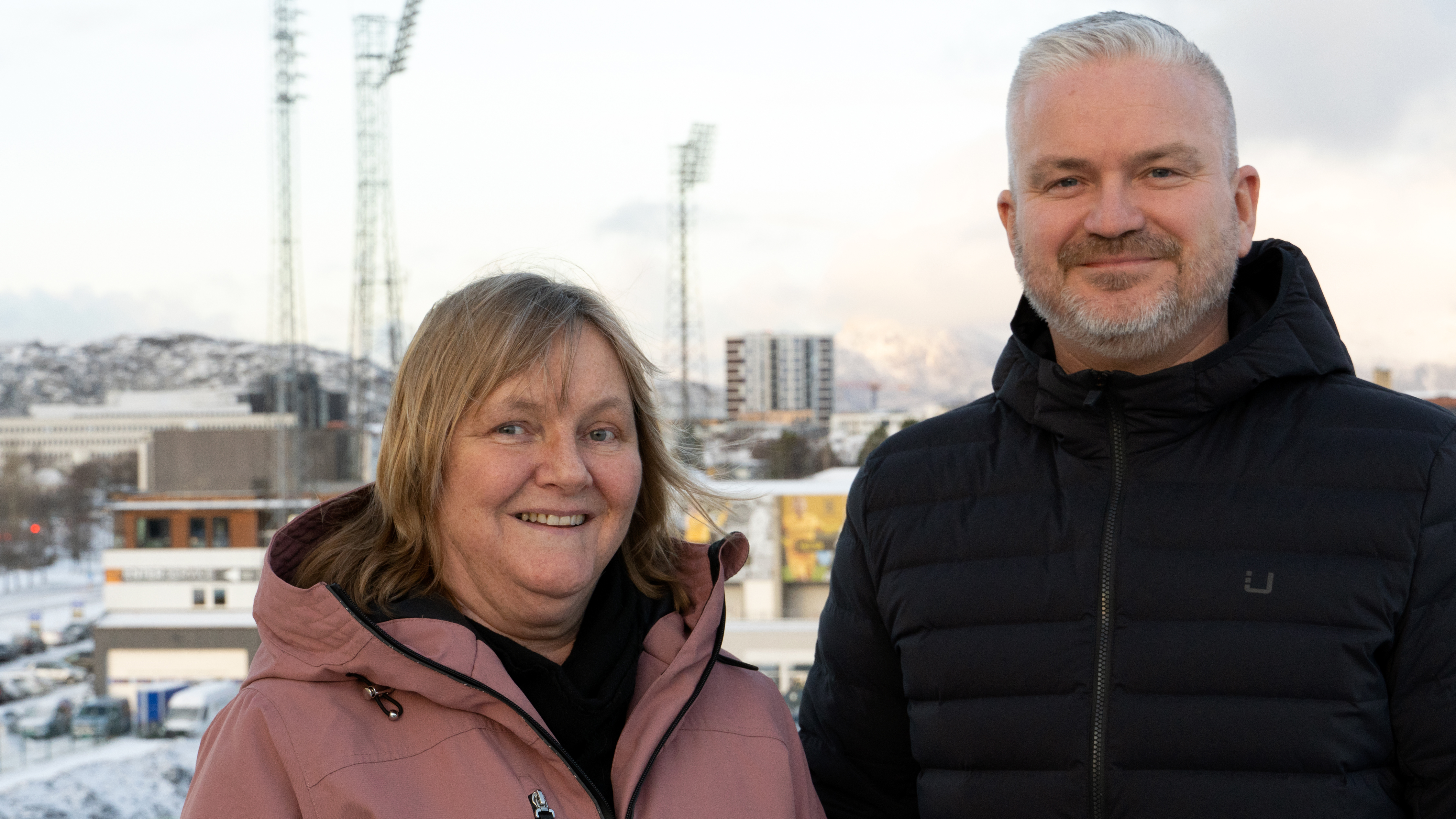 Monica Sande og Tom Cato Karlsen på takterasse med Aspmyra og Bodø sentrum i bakgrunnen.
