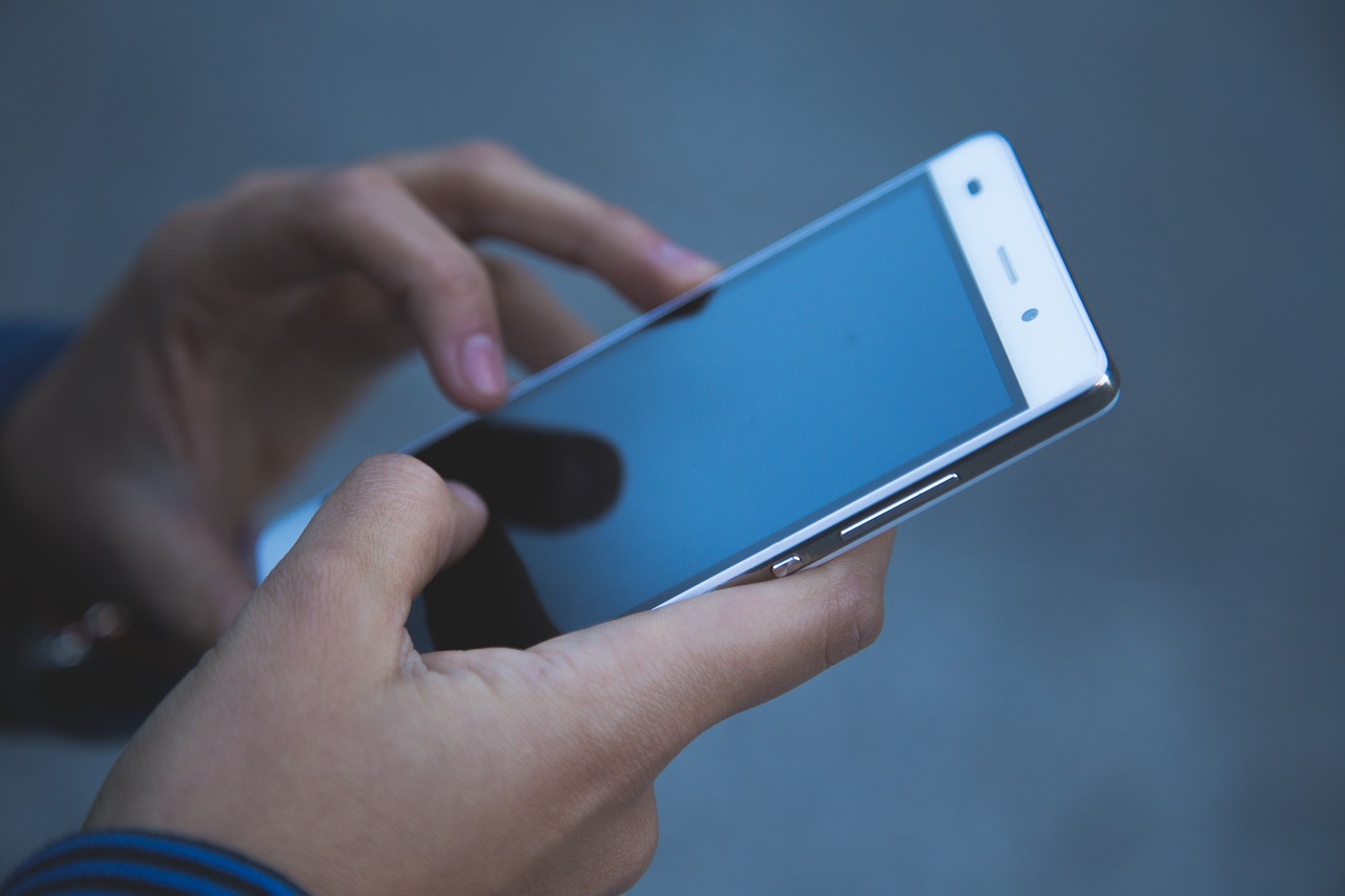 To hender som held i ein mobiltelefon.
