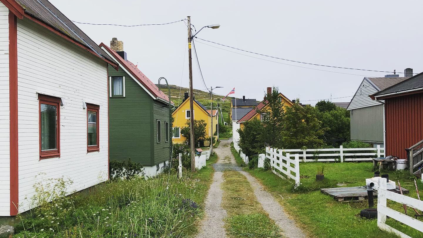 Rett grusvei med hus på begge sider.