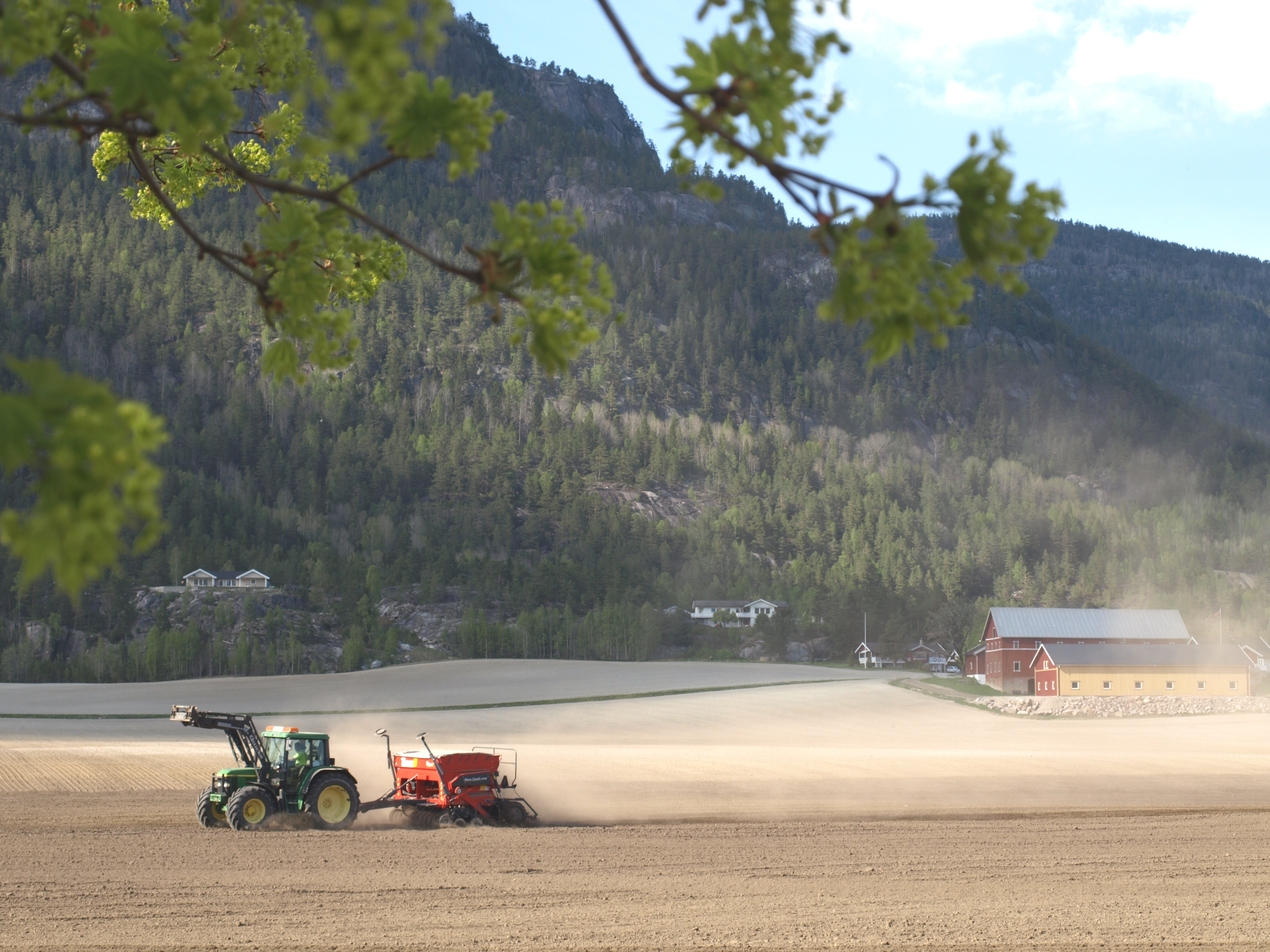 Traktor som kjører på jordet