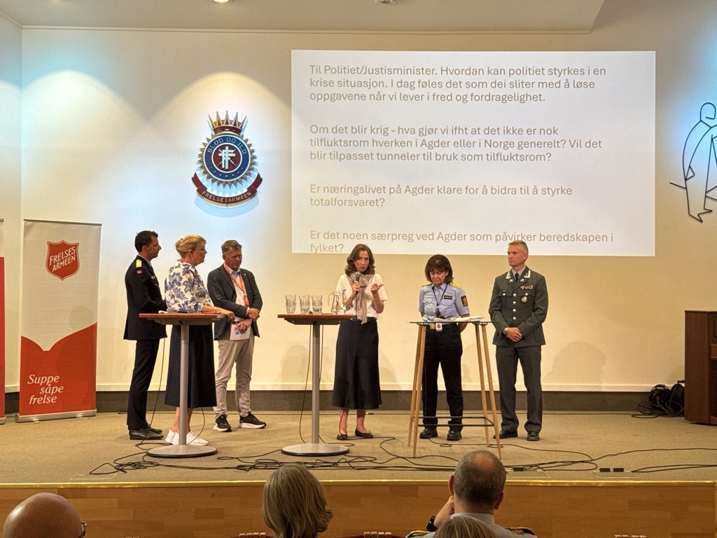 Panelet på scenen med justis- og beredskapsminister Astri Aas-Hansen i midten.