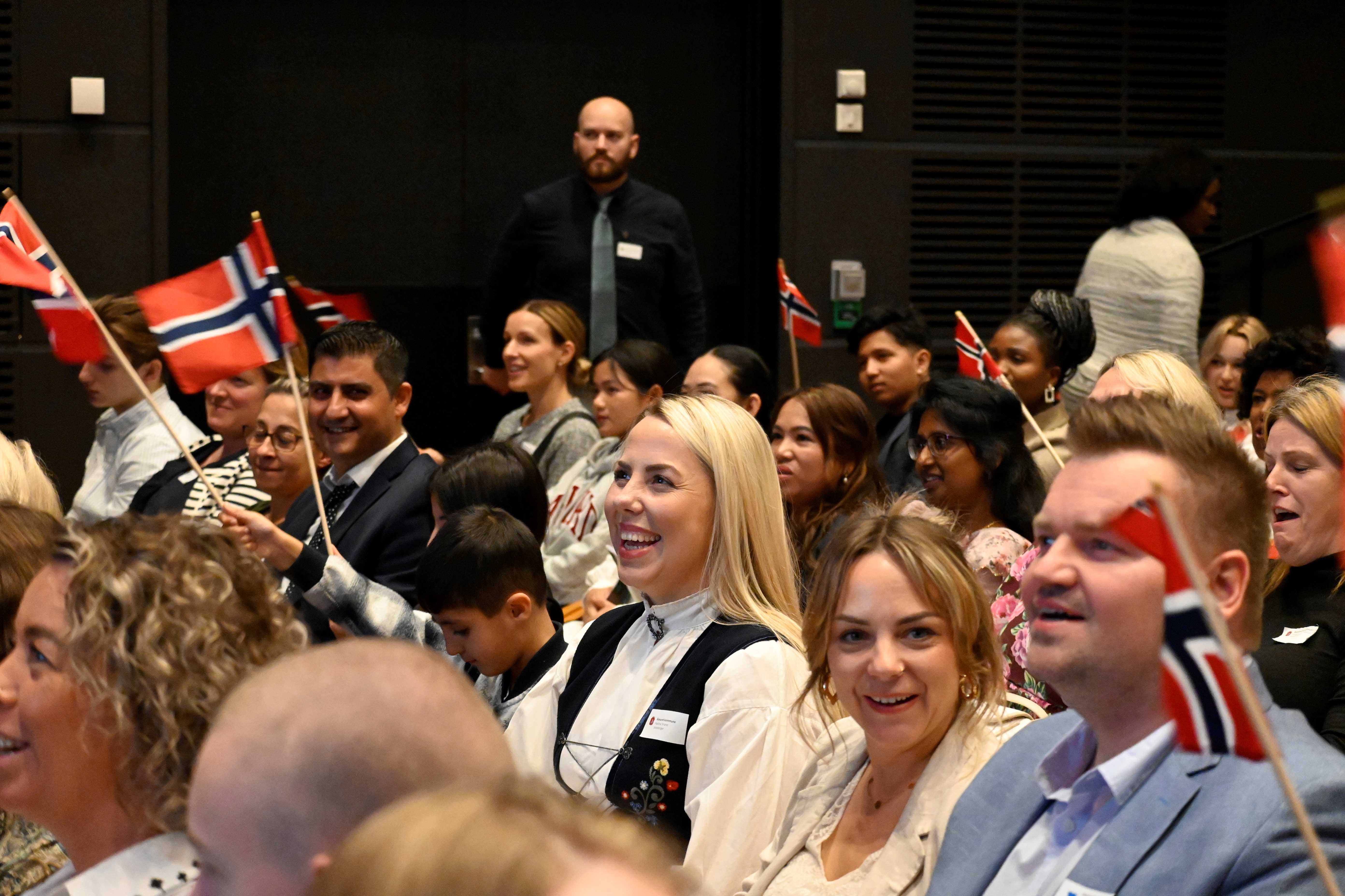 Ser glade menneske og flagg i salen