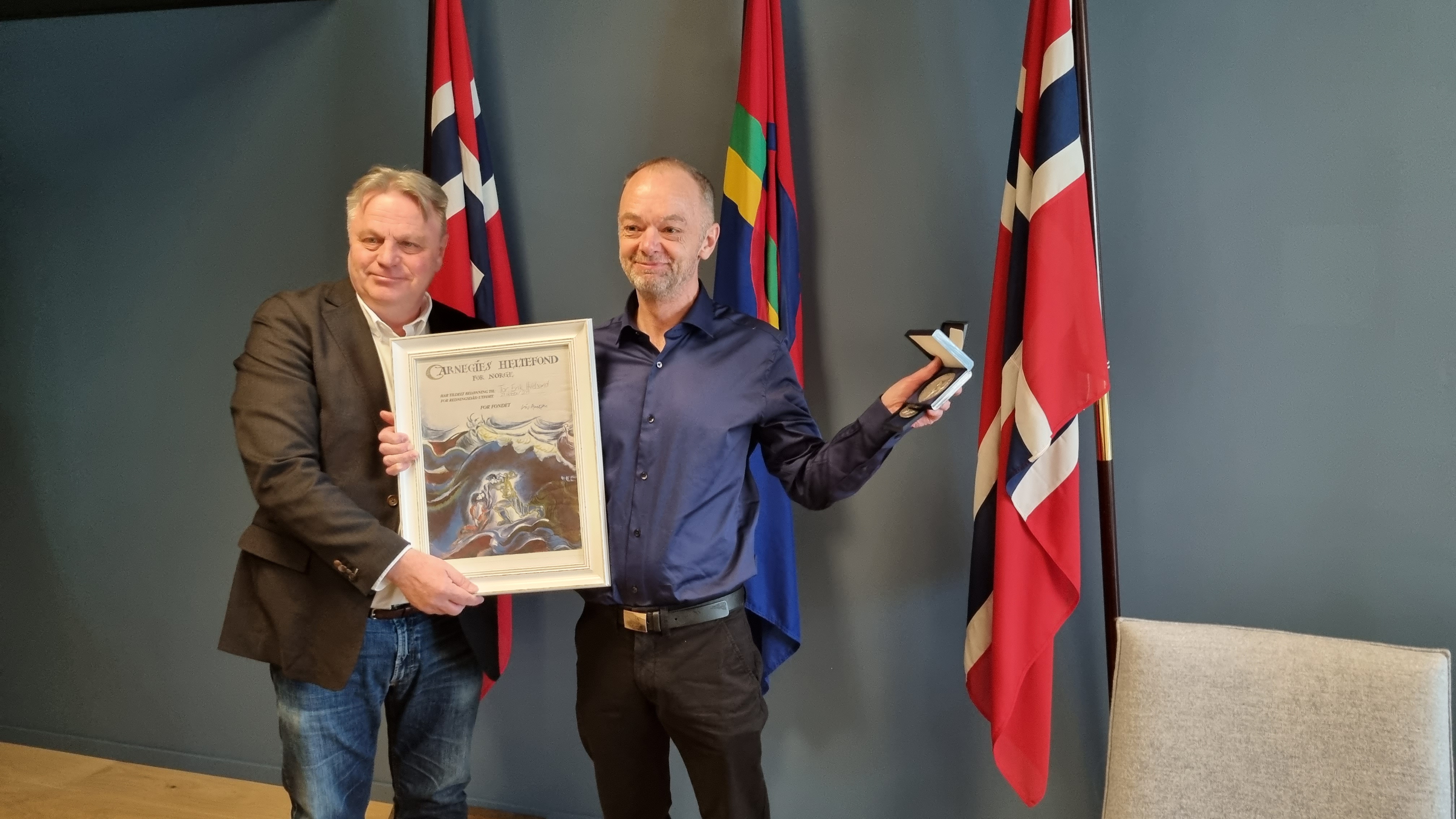 Her har Tor Erik Hvidsand nettopp fått overrekt sølvmedalje og diplom fra Carnegies heltefond for sin heroiske innsats i Kanalen i Trondheim i 2018. Det var fungerende statsforvalter Øystein Johannessen som hadde gleder av å å stå for overrekkelsen. 