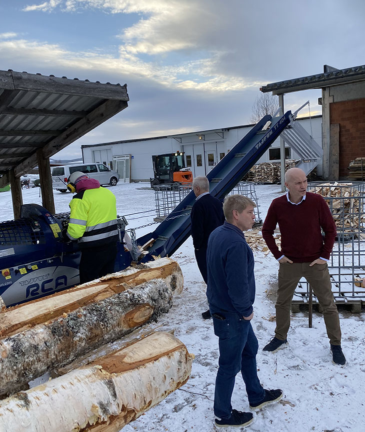 Tre menn som står utendørs ved oppkappet ved