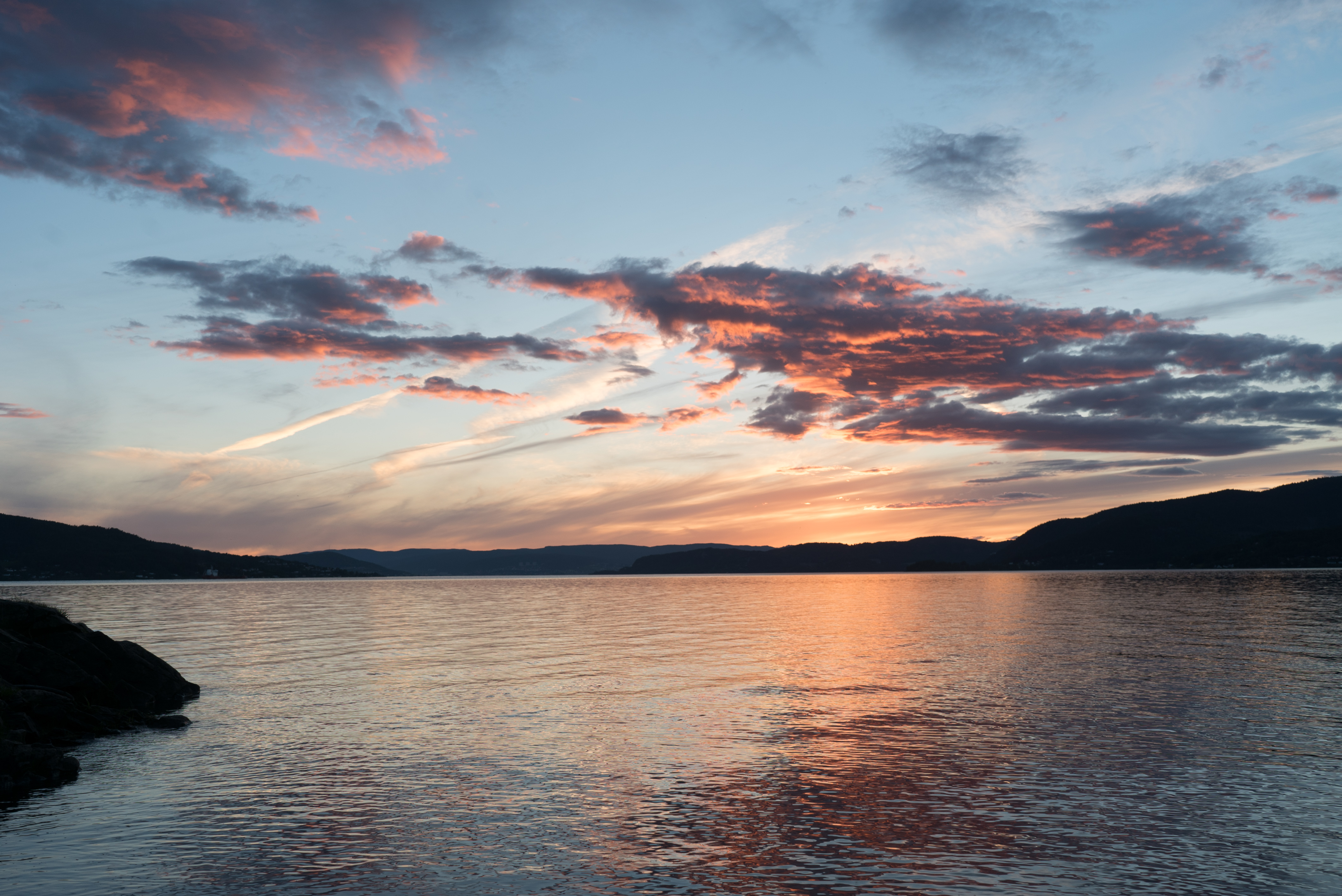 Bilde av en fjord i solnedgang.