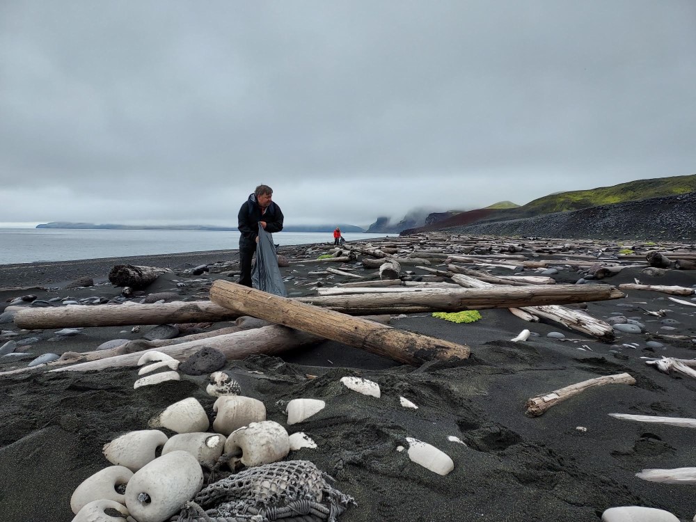Jan Mayen er kjent for sin rikdom på drivtømmer. Men også store mengder marint avfall skylles på land. Her ser vi  seniorrådgiver Åsmund Andersen fra klima- og miljøavdelinga rydder på Haugenstranda. 