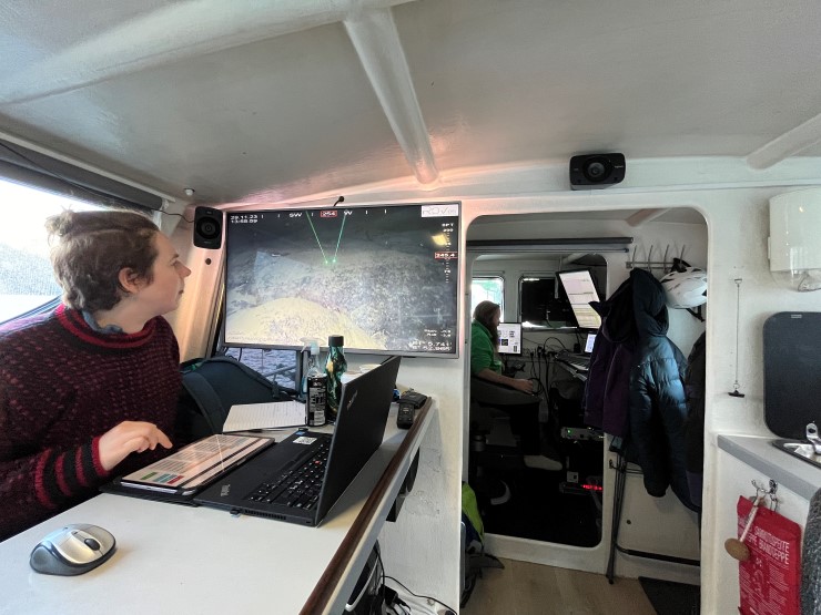 person ser på video av sjøbotn med pc framfor seg 