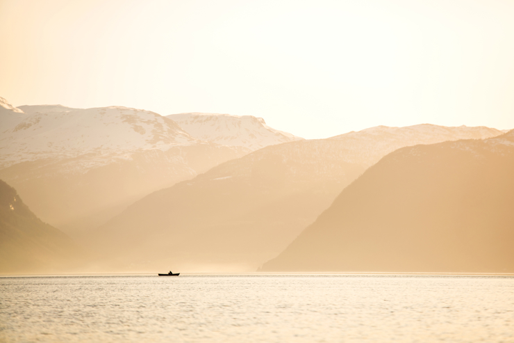 en robåt i eit landskap med fjell og fjord
