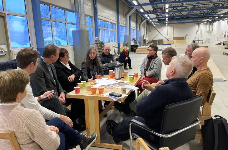 Folk som sitter rundt et bord og snakker